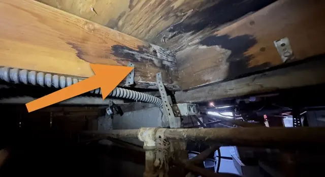 Manchas de humedad en la madera bajo la casa